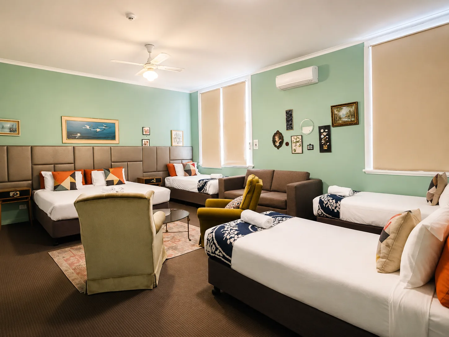 Family Room with green walls, king bed and lounge area at Vine Valley Inn Cessnock