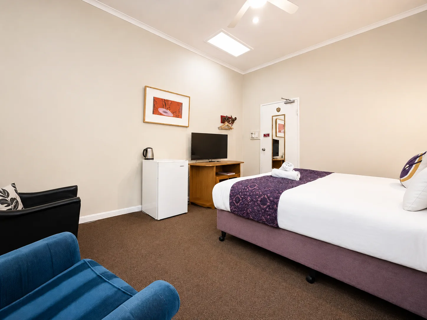 Bedroom with lounge seating — King Room at Vine Valley Inn Cessnock