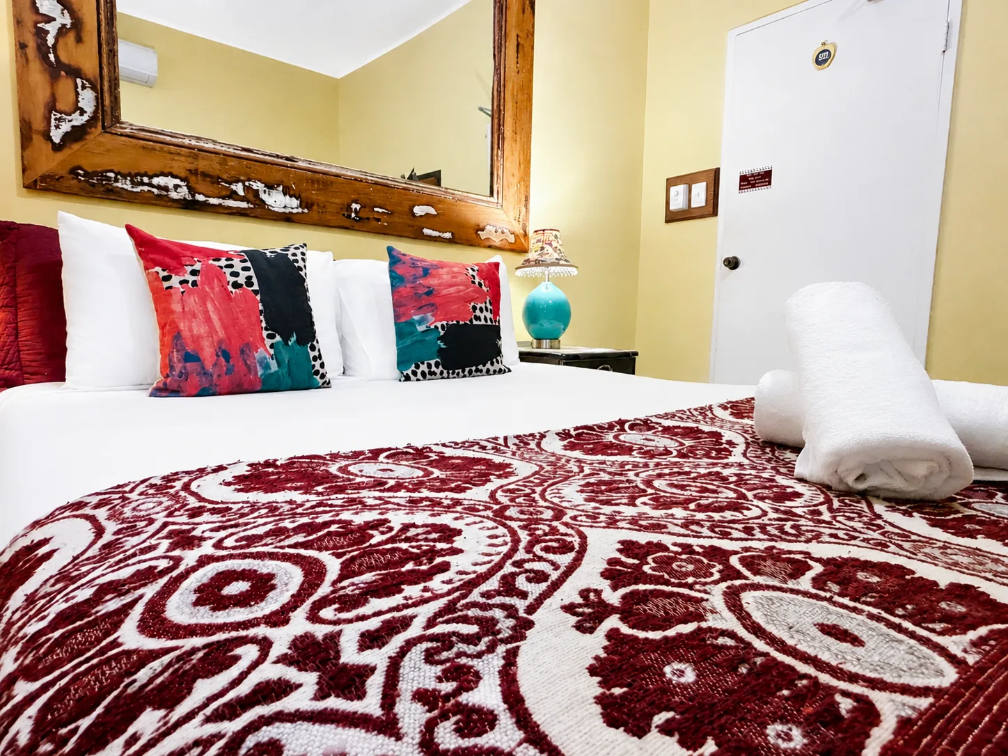 Queen bed with bold scatter cushions — Queen Deluxe Room at Vine Valley Inn Cessnock